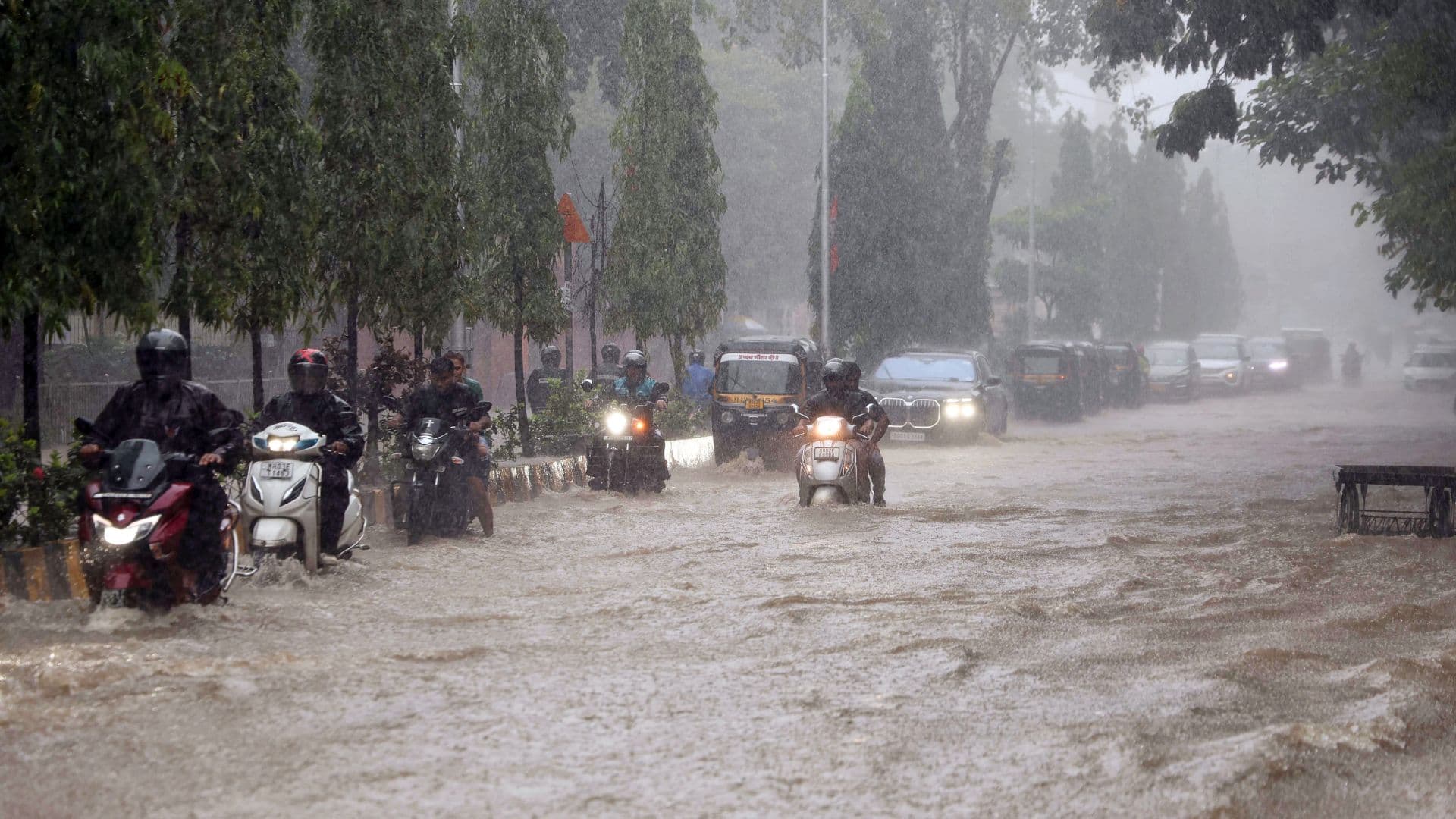 Vehicles wade through a waterlogged road in Mumbai