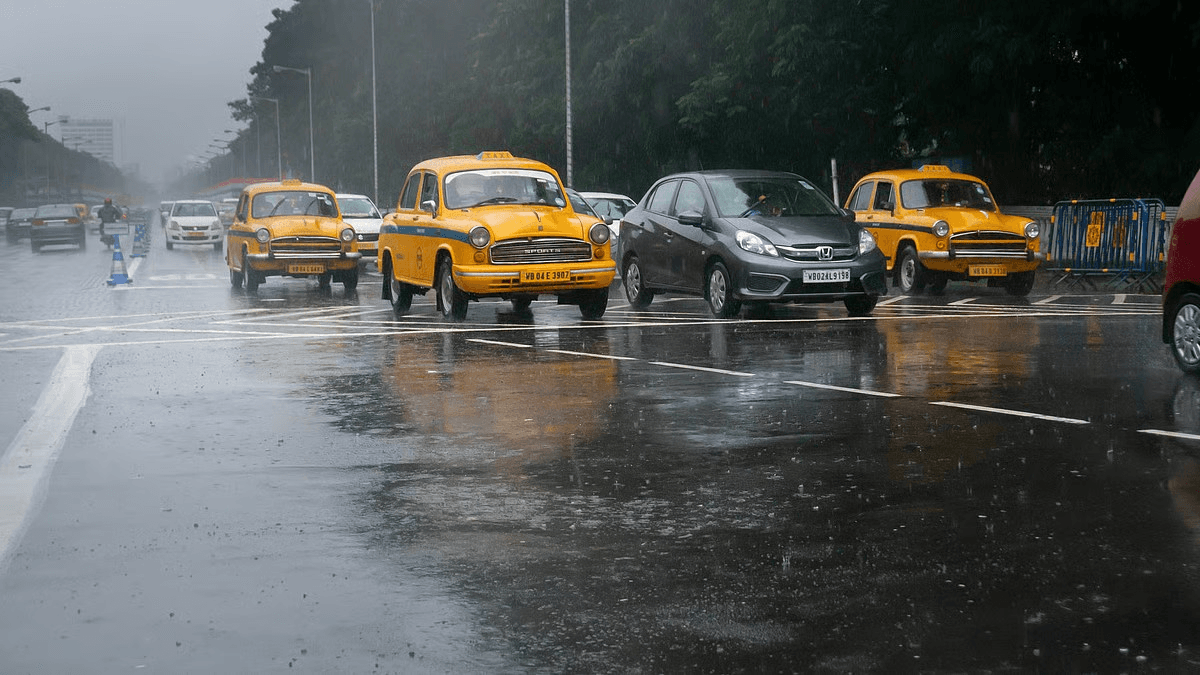 Vehicles move through heavy rain on a Kolkata road