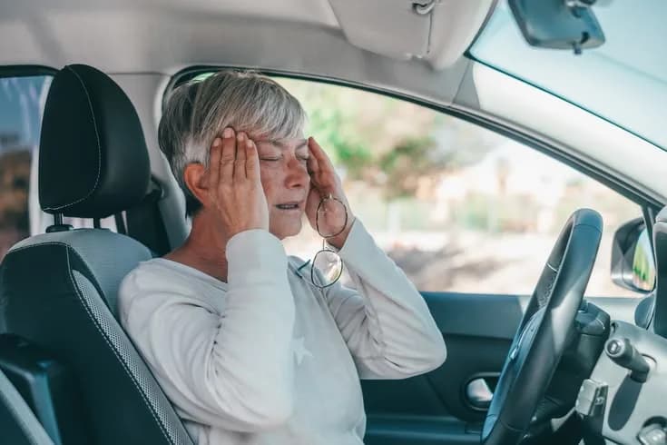Person feeling nauseous in a moving car