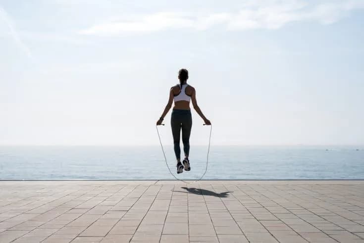 A person performing repeated jumps during a workout as part of a daily fitness challenge.